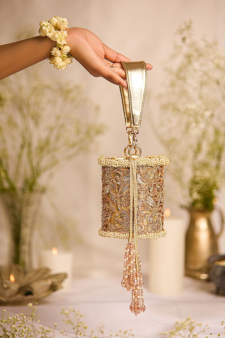 Golden Faux Leather Tasseled Cylindrical Potli Bag by 5 Elements at Pernia's Pop Up Shop
