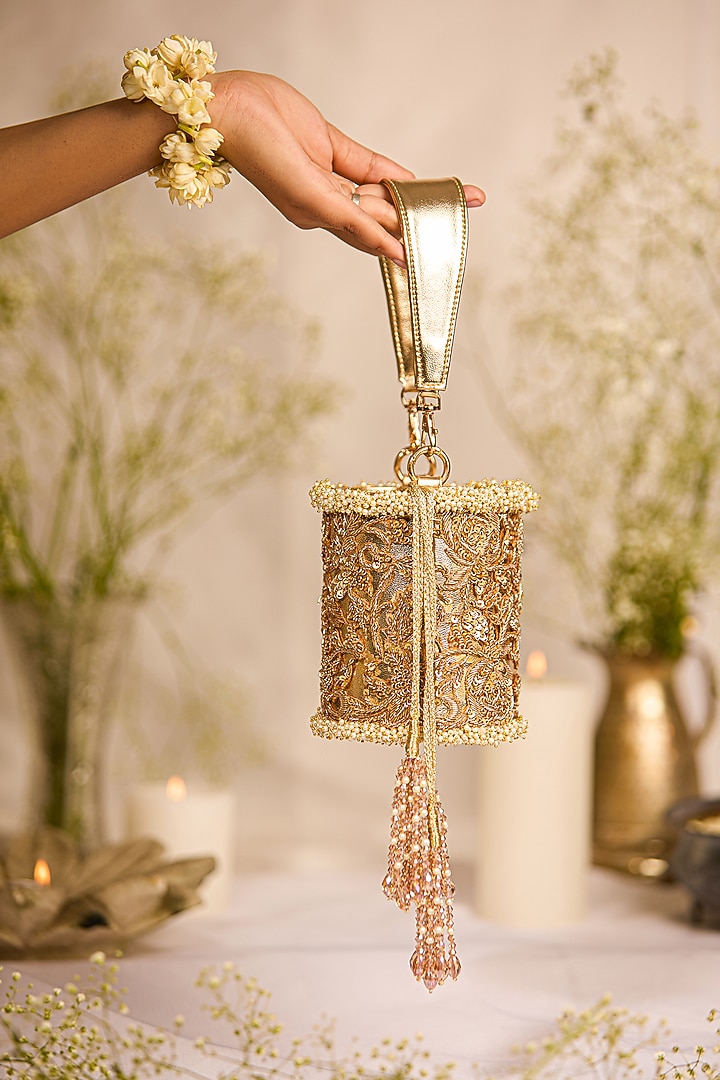 Golden Faux Leather Tasseled Cylindrical Potli Bag by 5 Elements at Pernia's Pop Up Shop