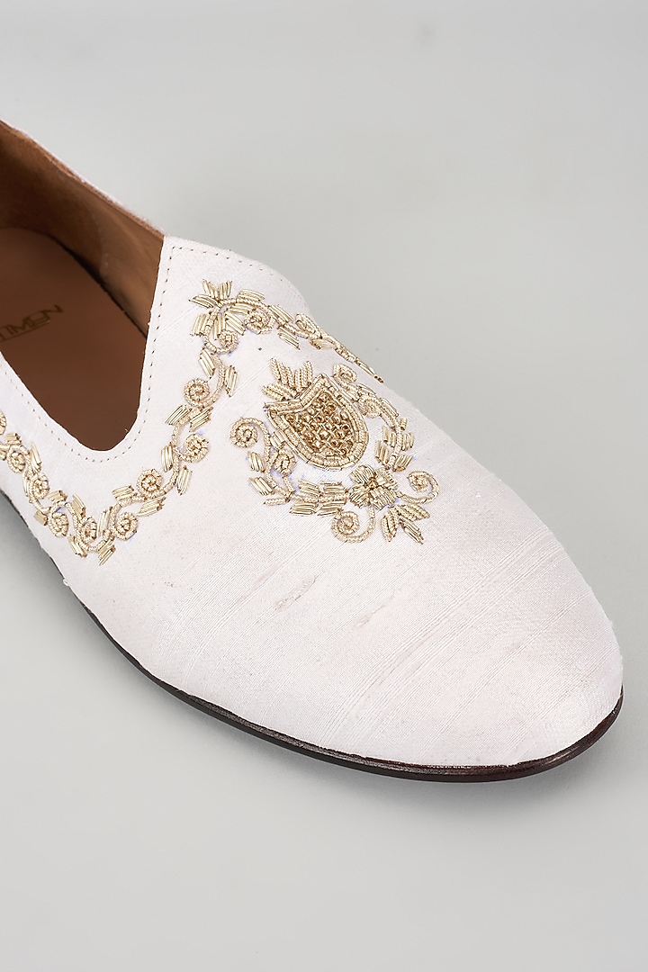 Ivory Raw Silk Hand Embroidered Juttis by ARTIMEN at Pernia's Pop Up Shop