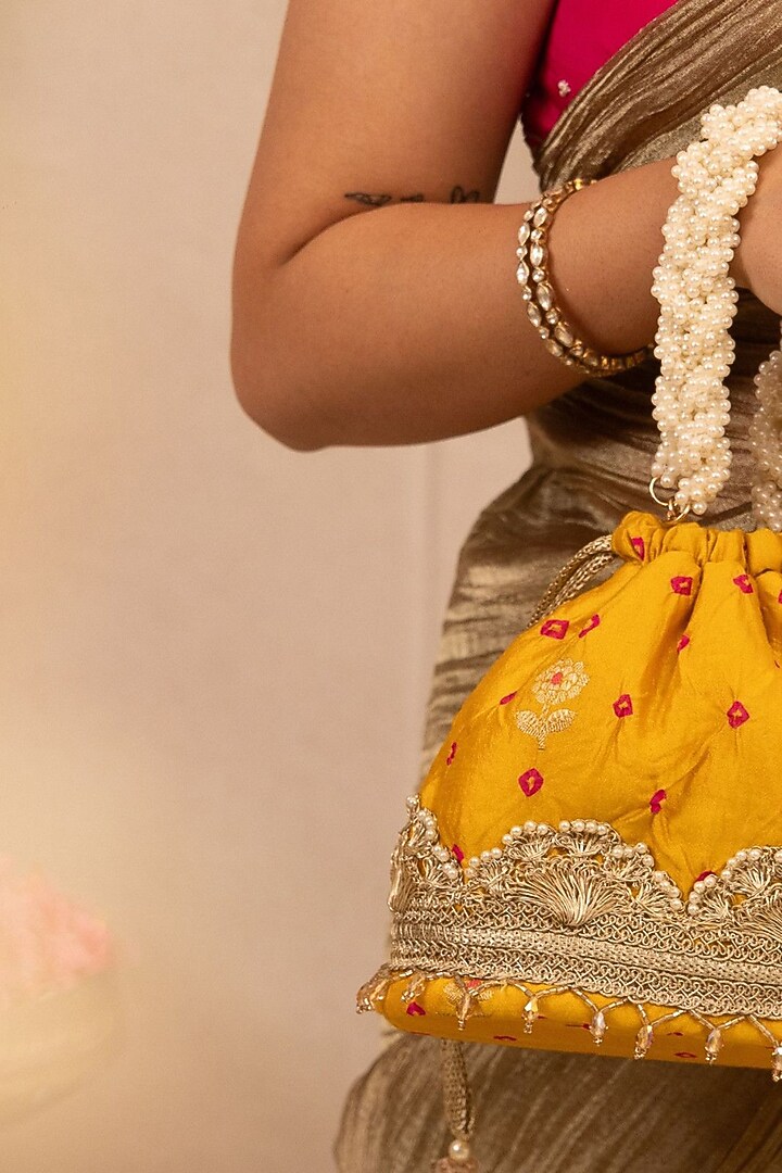 Mustard Bandhani Silk Lace Embellished Bucket Bag by AMYRA at Pernia's Pop Up Shop