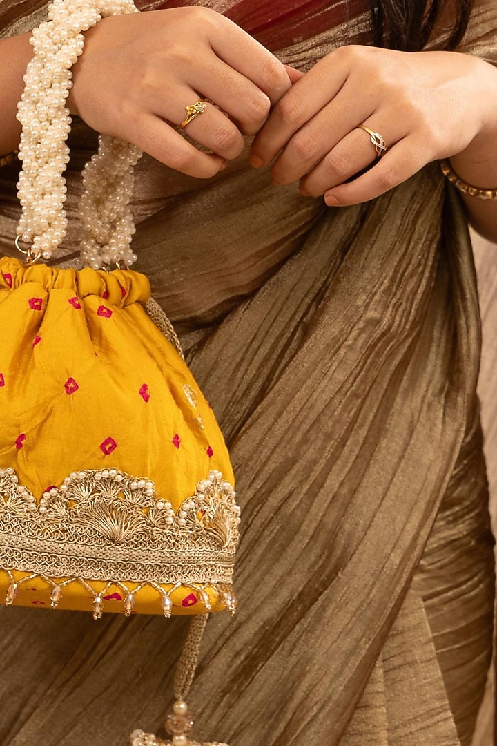 Mustard Bandhani Silk Lace Embellished Bucket Bag by AMYRA at Pernia's Pop Up Shop