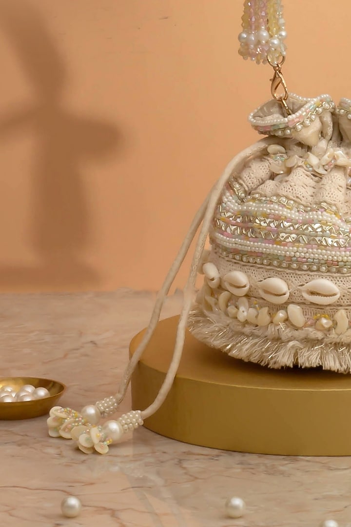 Off-White Poly Silk Cutdana Embellished Potli by AMYRA at Pernia's Pop Up Shop