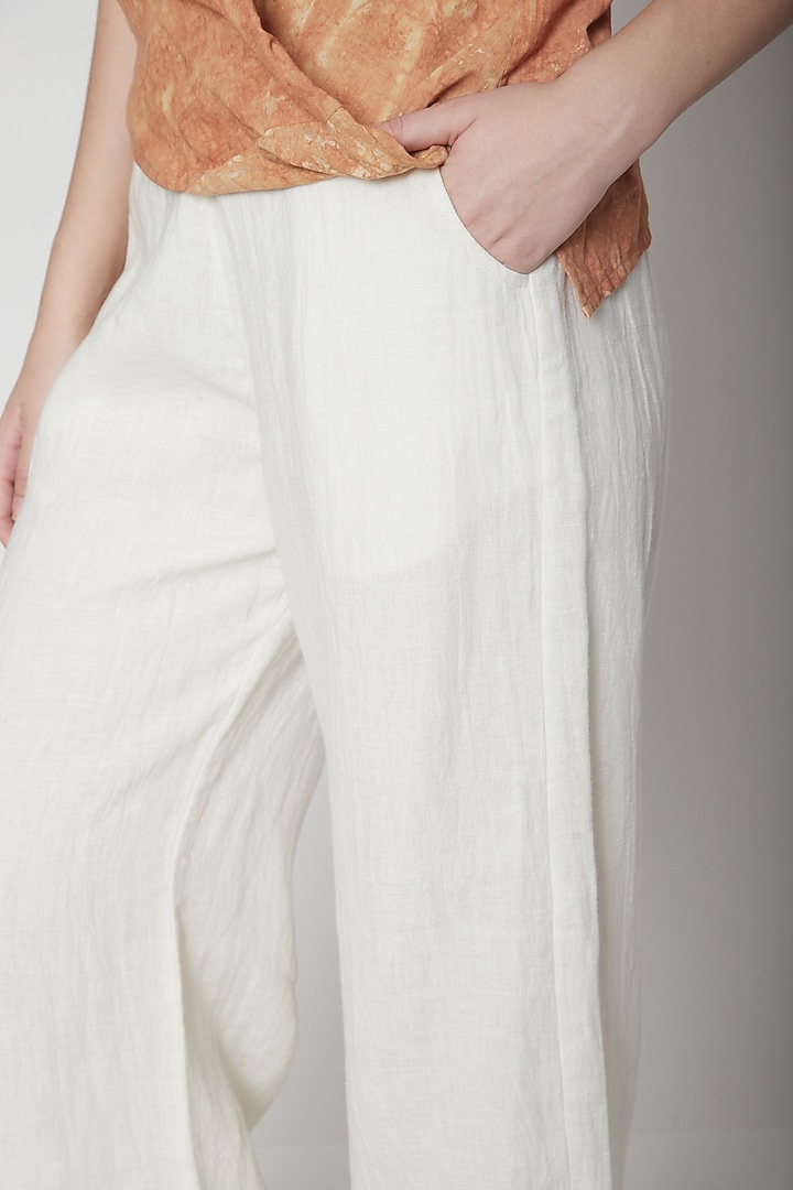 White Flared Pants With Pockets by AURUHFY at Pernia's Pop Up Shop