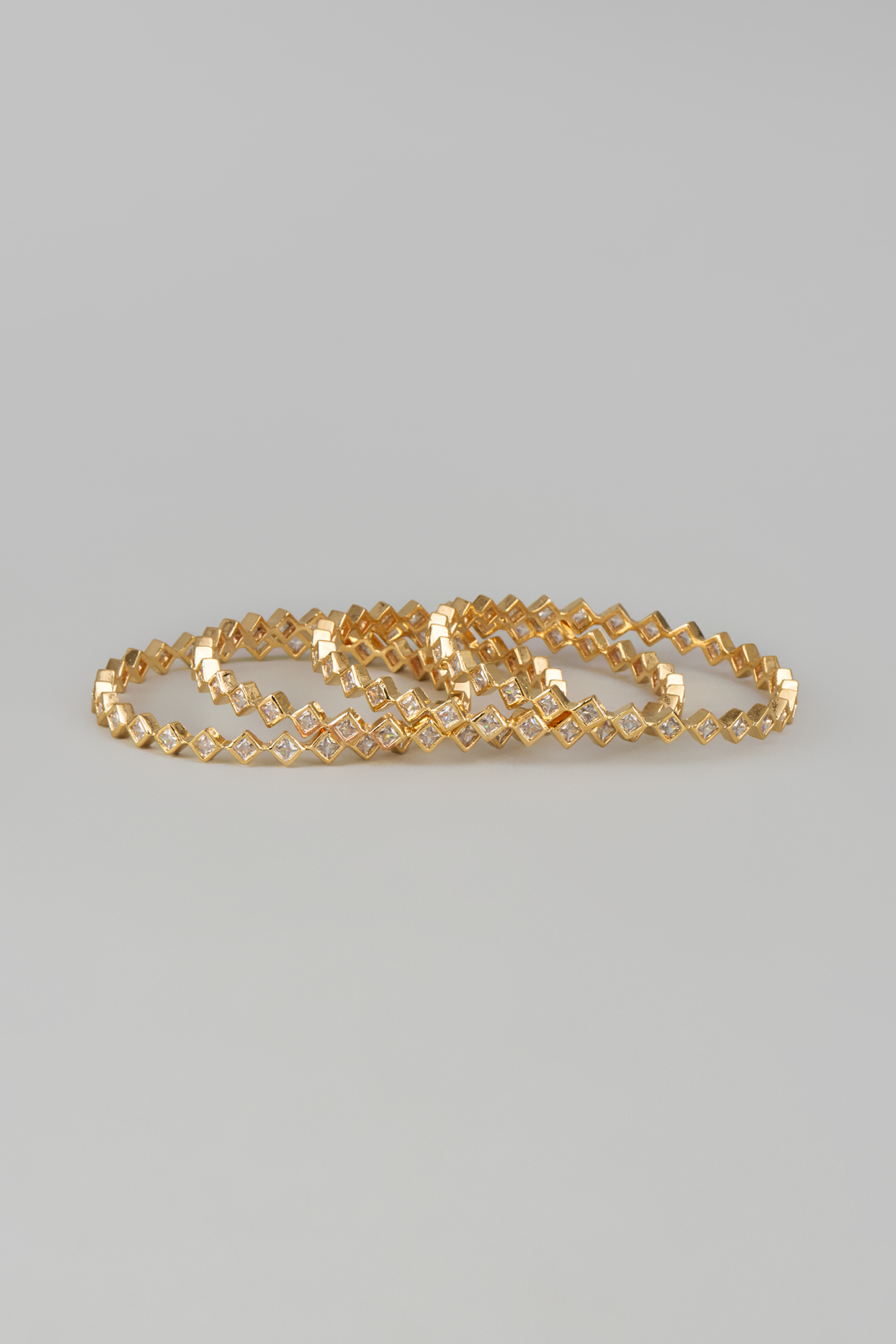 Gold Finish Zircon Bangles (Set of 4) by Aster at Pernia's Pop Up Shop