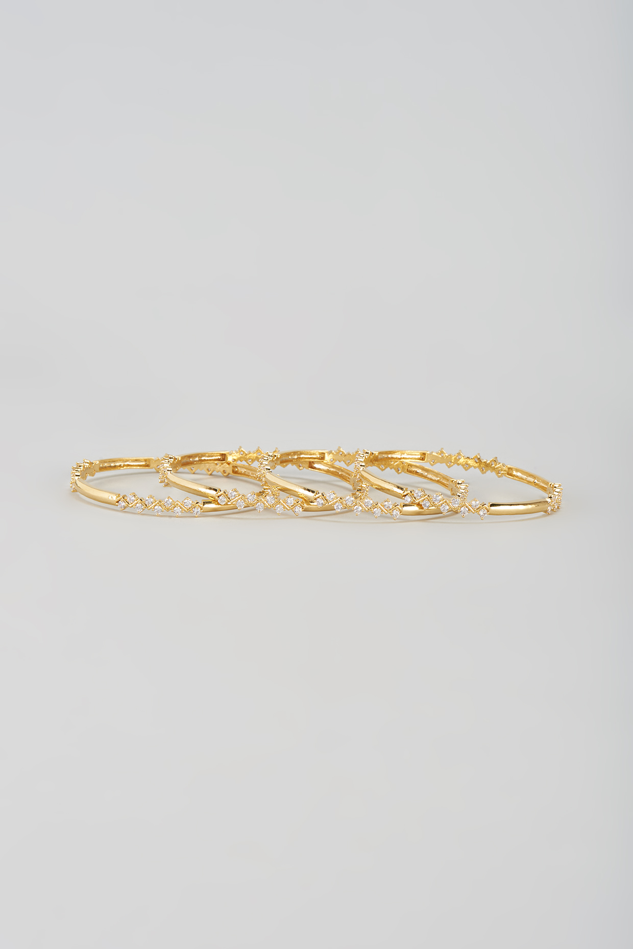 Gold Finish Zircon Bangles (Set of 4) by Aster at Pernia's Pop Up Shop