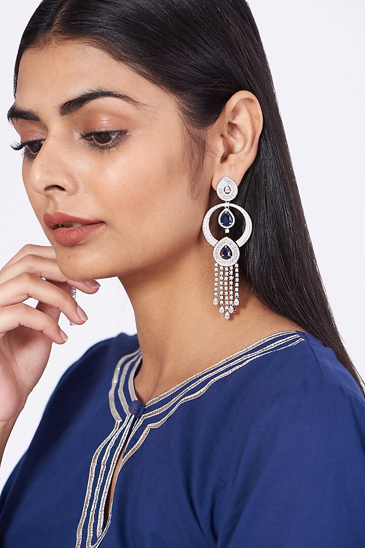 White Finish Dangler Earrings With Blue Stones by Aster at Pernia's Pop Up Shop