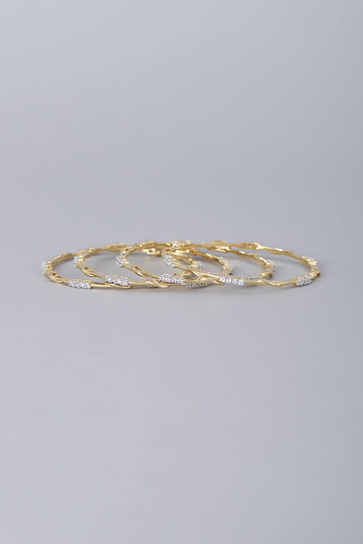 Gold Finish Zircon Bangles (Set of 4) by Aster at Pernia's Pop Up Shop