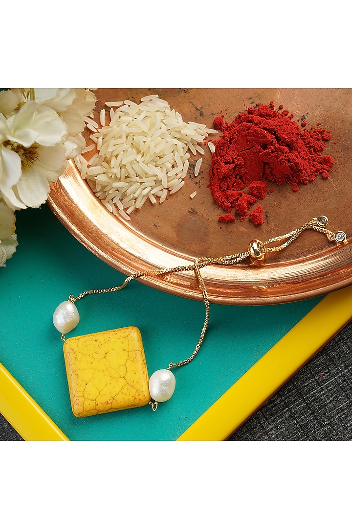 Gold Finish Bracelet Rakhi With Semi-Precious Onyx Stone by Aura Trends at Pernia's Pop Up Shop