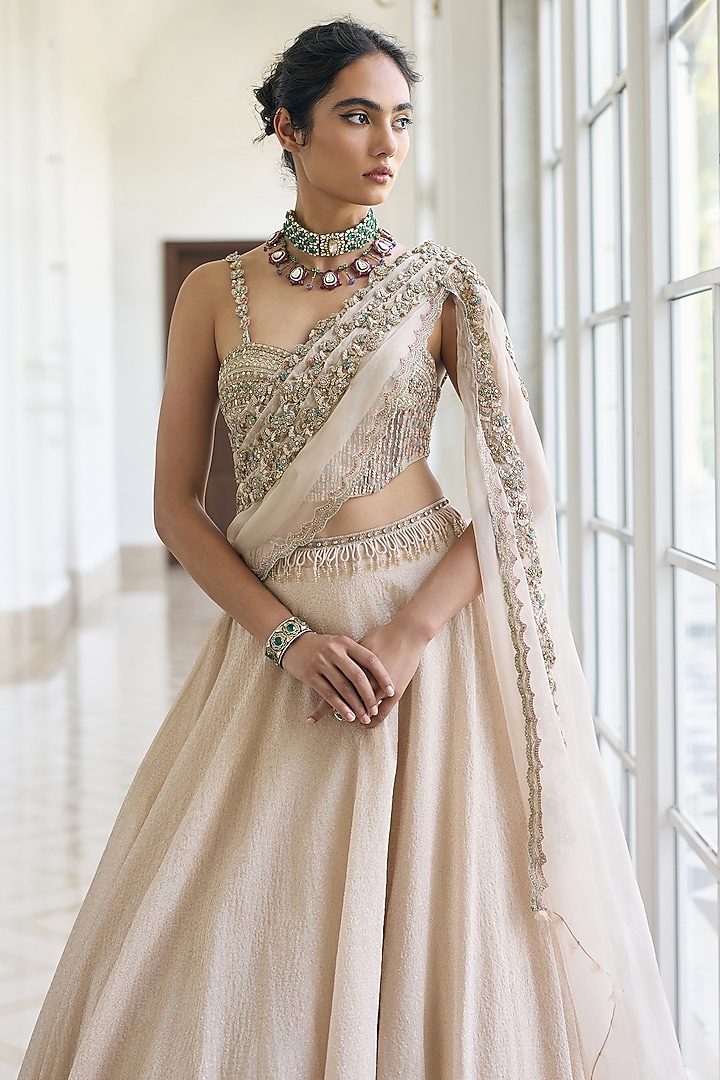 Ivory Modal Satin Embellished Draped Wedding Lehenga Set by AWIGNA BY VARSHA & RITTU at Pernia's Pop Up Shop
