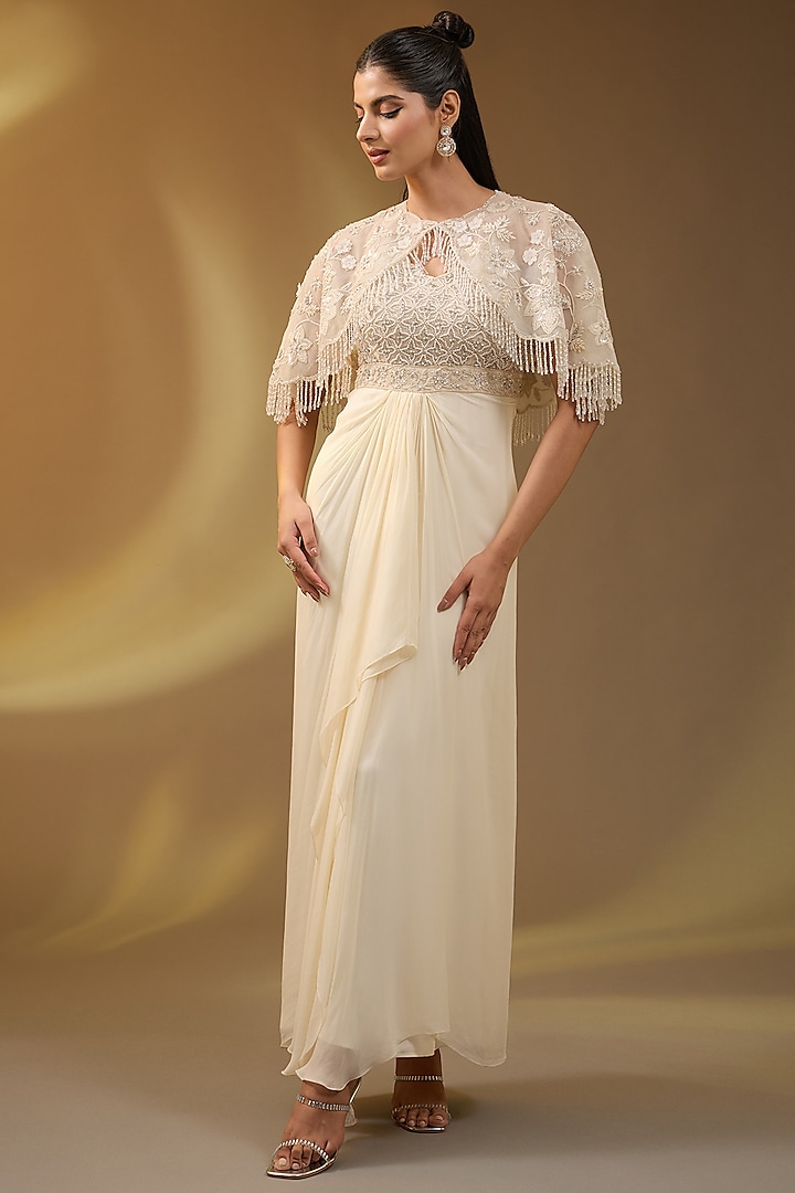 Ivory Net & Georgette Embroidered Stitched Draped Gown With Cape by Devika Bhayana at Pernia's Pop Up Shop