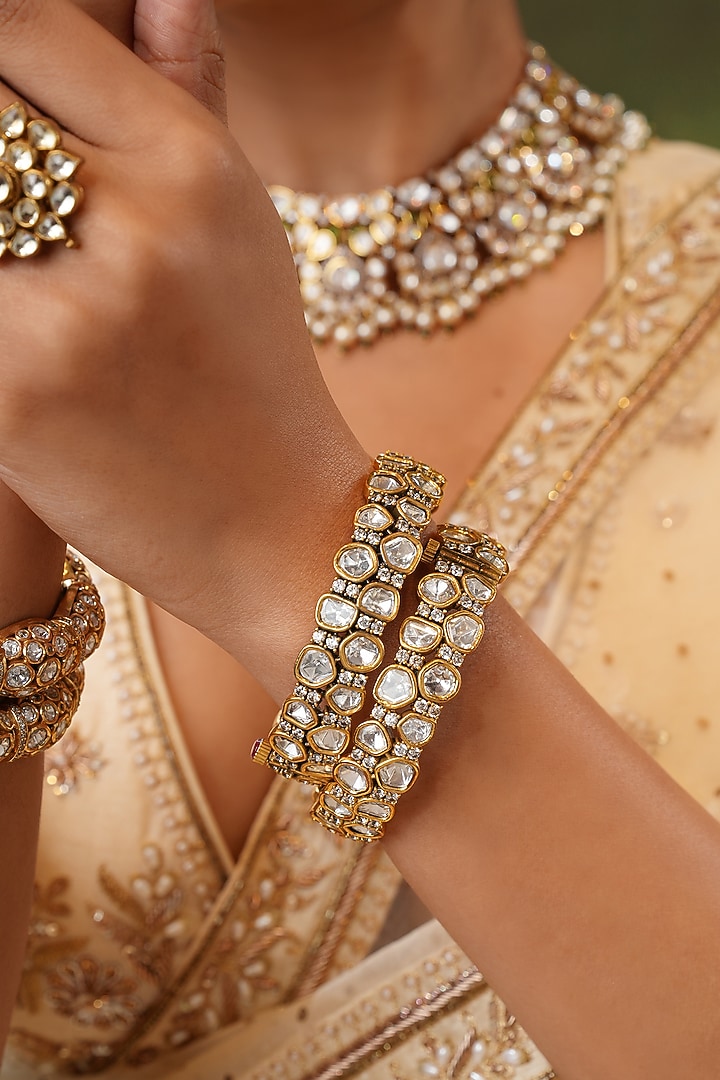 Gold Finish Kundan Polki Floral Bangles (Set Of 2) by EKATHVA JAIPUR at Pernia's Pop Up Shop