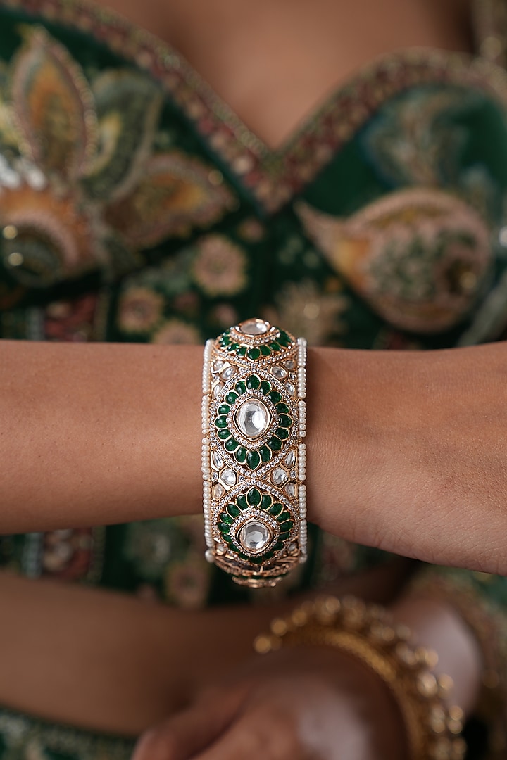 Gold Finish Kundan Polki & Green Stone Floral Bangles (Set Of 2) by EKATHVA JAIPUR at Pernia's Pop Up Shop