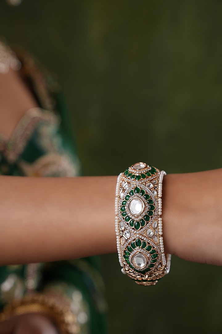 Gold Finish Kundan Polki & Green Stone Floral Bangles (Set Of 2) by EKATHVA JAIPUR at Pernia's Pop Up Shop