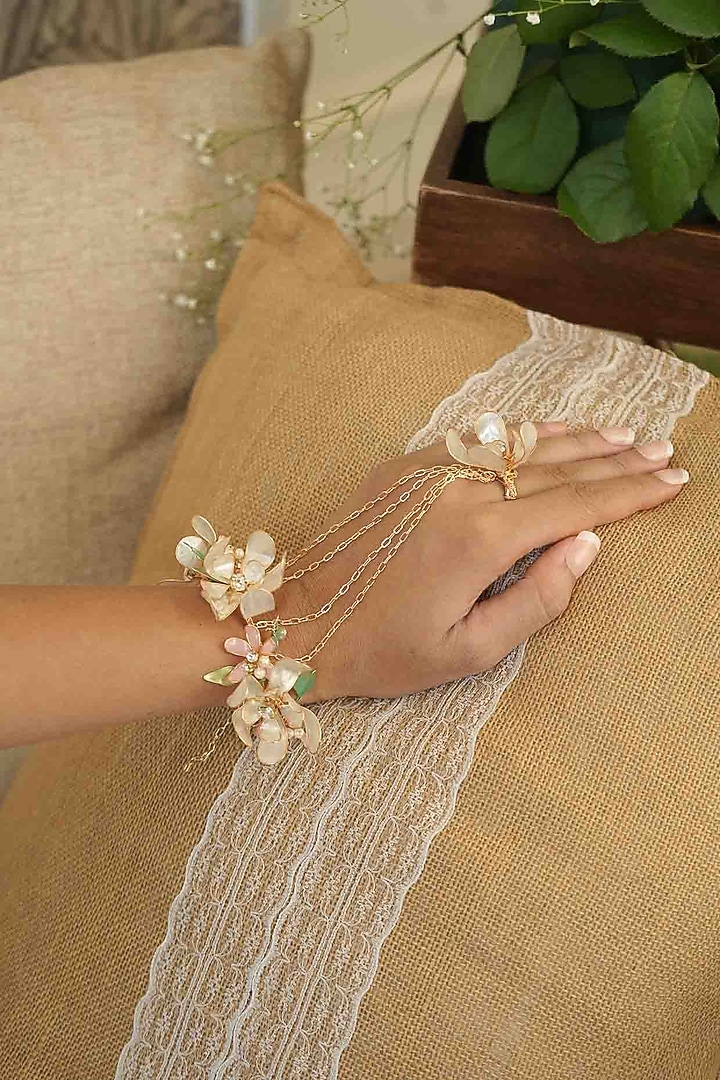 Gold Finish Off-White Gemstone & Resin Floral Hathphool (Set of 2) by FLORISTAA BY MAHEK at Pernia's Pop Up Shop