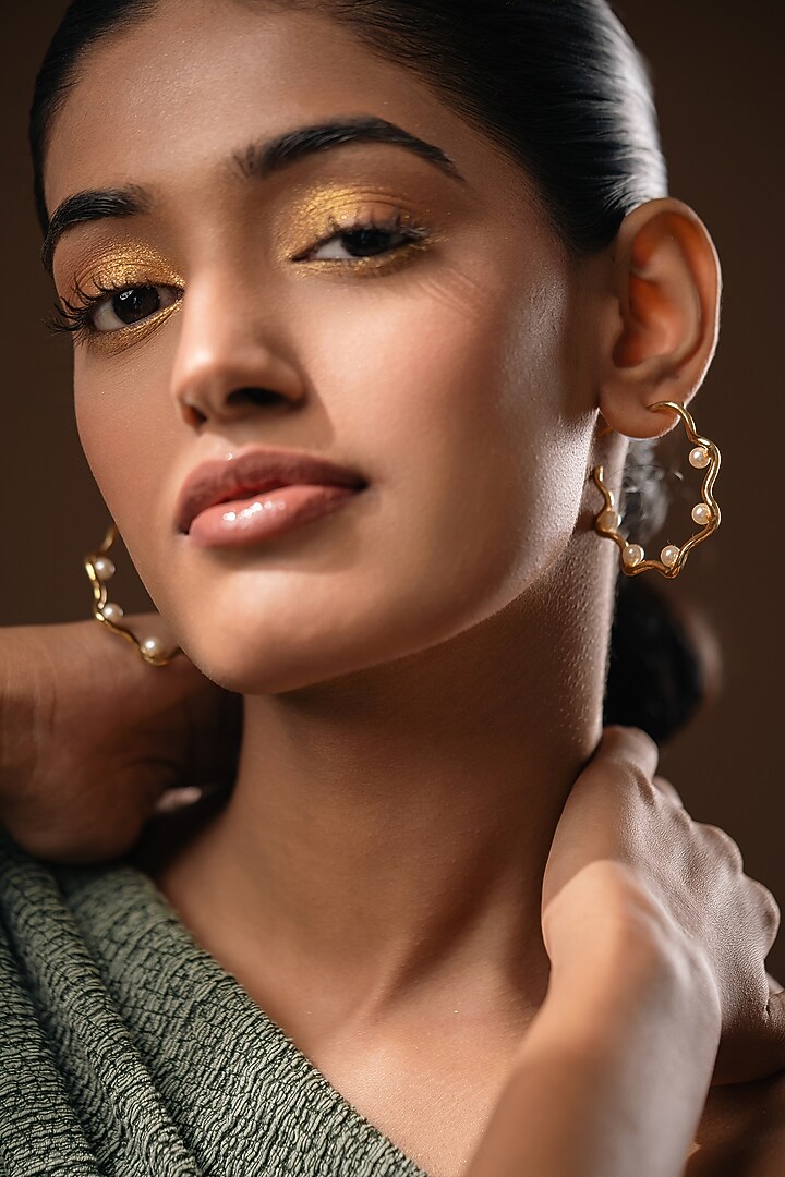Gold Finish Pearl Handcrafted Swirl Hoop Earrings by Hermosa By Srishti Bajaj at Pernia's Pop Up Shop
