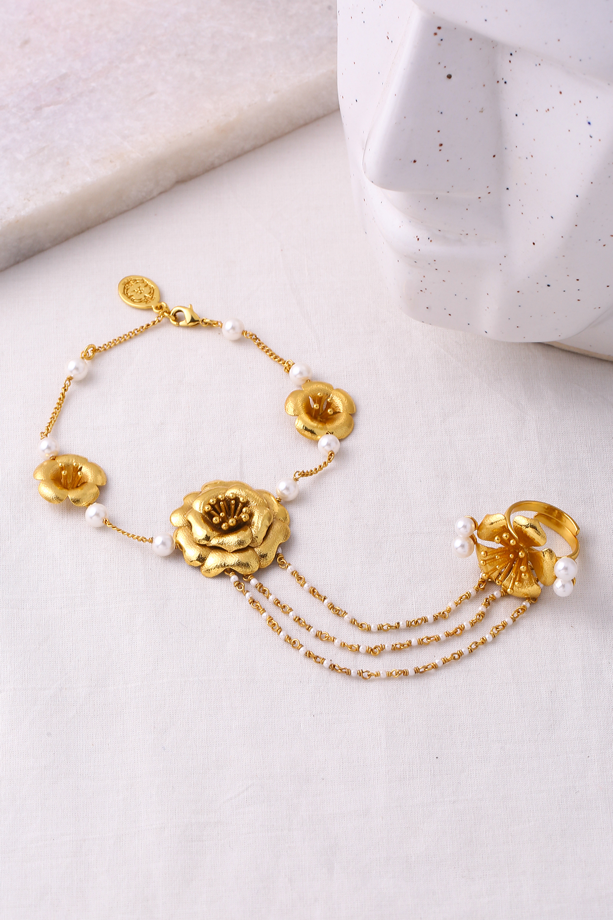 Gold Finish Pearl Floral Hand Harness by Jewellery by Astha Jagwani