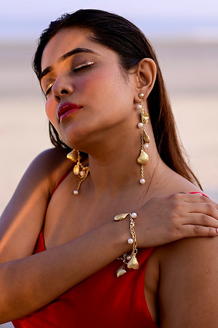 Gold Finish Pearl Handcrafted Dangler Earrings With Bracelet by NIHIRAA INDIA at Pernia's Pop Up Shop