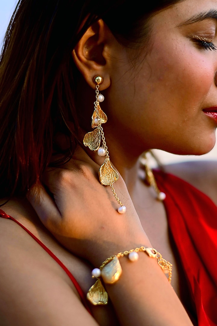 Gold Finish Pearl Handcrafted Dangler Earrings With Bracelet by NIHIRAA INDIA at Pernia's Pop Up Shop