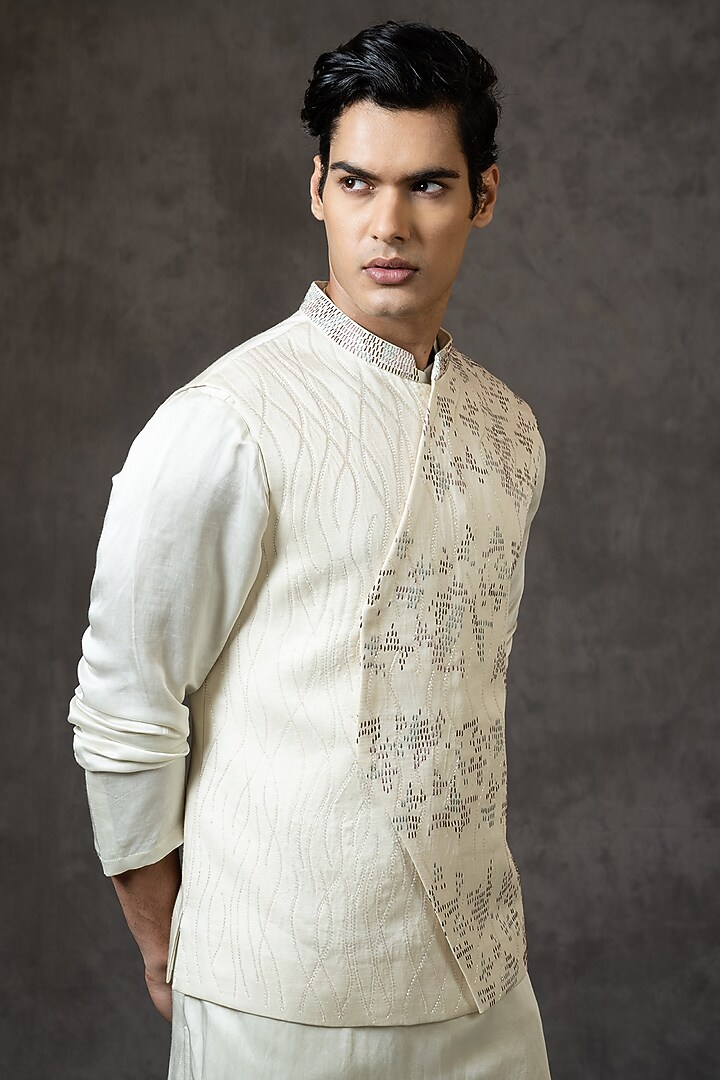 Ivory Linen Satin Cutdana Embroidered Asymmetric Bundi Jacket by PAARSH at Pernia's Pop Up Shop