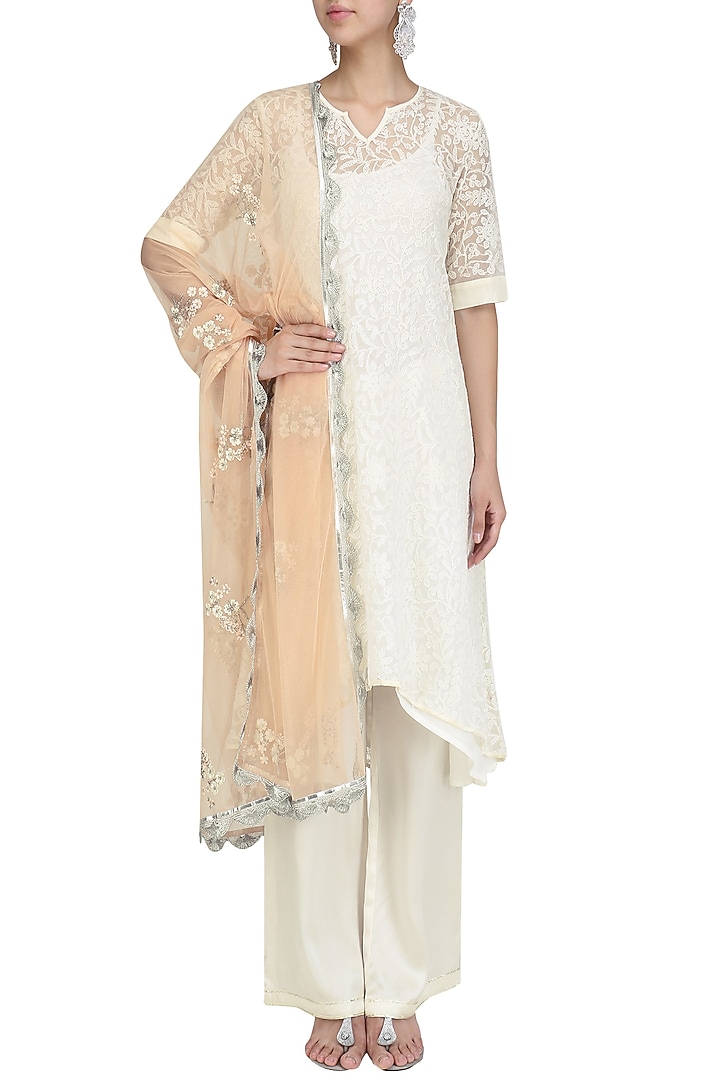 Ivory chikankari kurta set with peach dupatta available only at Pernia's Pop Up Shop.