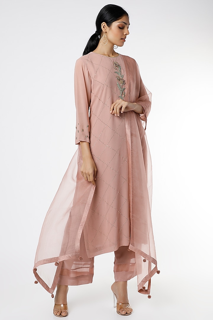 Featuring a dusty pink kurta in georgette base with zardosi and thread hand embroidered tulips. It is paired with matching pyjama pants and an organza dupatta.

FIT: Fitted at bust and waist.
COMPOSITION: Organza, Georgette.
CARE: Dry clean only. by Romaa