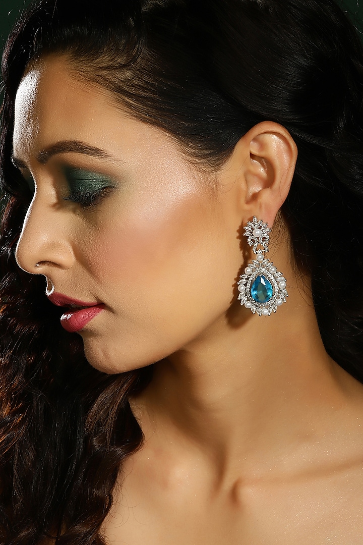 White Finish Sky Blue Zircon Dangler Earrings by Ritu Singh