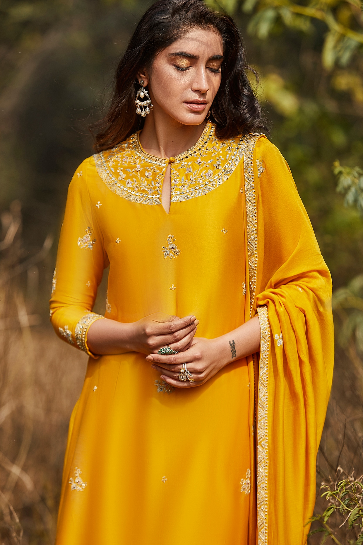 A beautiful asian girl sitting on the window wearing indian traditional yellow  kurti with beautiful earrings. Stock Photo | Adobe Stock