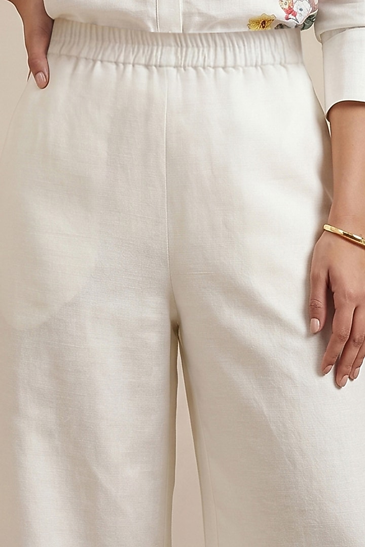 Off-White Linen Floral Motif Printed Pants by Satya Paul at Pernia's Pop Up Shop