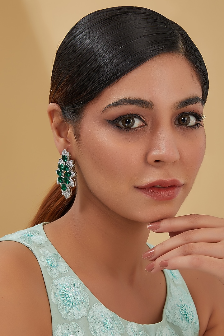 White Finish Zircon & Emerald Dangler Earrings In Sterling Silver by STELLA CREATIONS at Pernia's Pop Up Shop