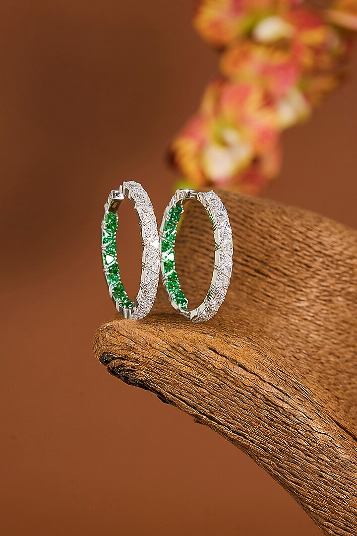 White Gold Finish Zircon & Emerald Stone Hoop Earrings In Sterling Silver by STELLA CREATIONS at Pernia's Pop Up Shop