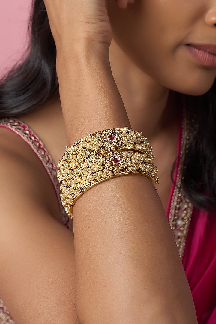 Gold Finish Pearl & Red Stone Temple Bangles (Set Of 2) by VASTRAA Jewellery at Pernia's Pop Up Shop