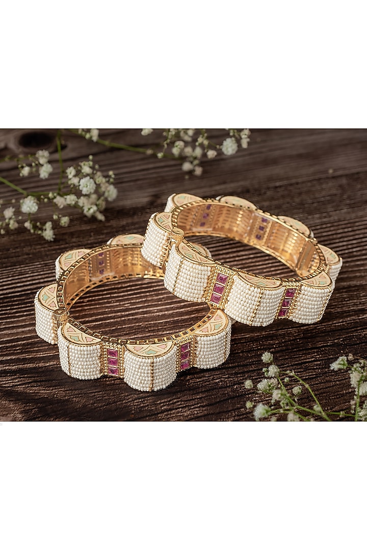 Gold Finish Pink Stones & White Beaded Bangles (Set Of 2) by Vivinia By Vidhi Mehra at Pernia's Pop Up Shop