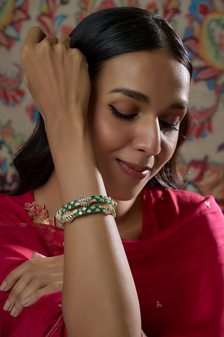 Gold Finish Emerald Synthetic Stone Bangles (Set of 2) by Vivinia By Vidhi Mehra at Pernia's Pop Up Shop