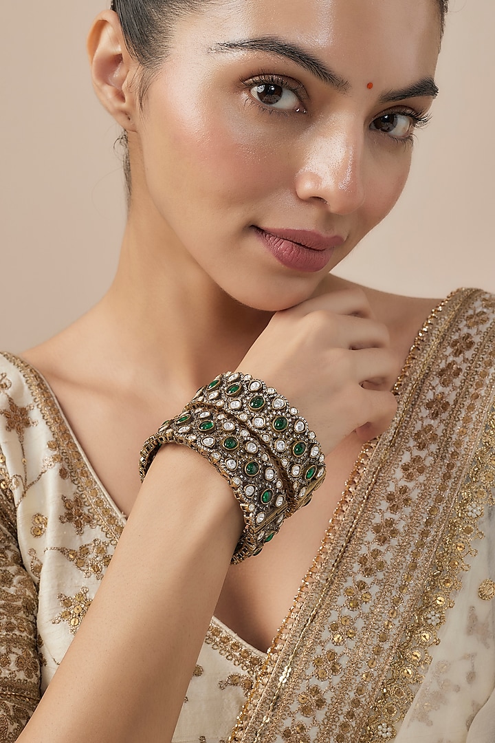 Gold Finish Kundan Polki & Green Stone Bangles (Set Of 2) by Vivinia By Vidhi Mehra at Pernia's Pop Up Shop