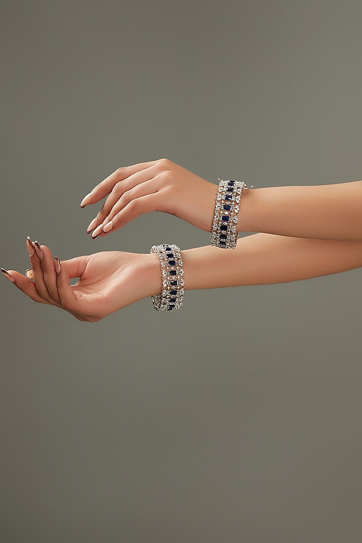 White Finish Faux Diamond & Sapphire Stone Bangles (Set of 2) by Zevar By Geeta at Pernia's Pop Up Shop