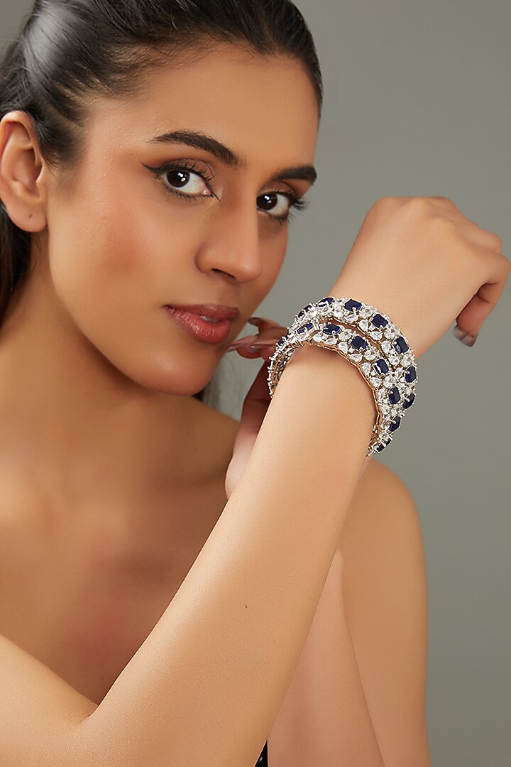 White Finish Faux Diamond & Sapphire Stone Bangles (Set of 2) by Zevar By Geeta at Pernia's Pop Up Shop