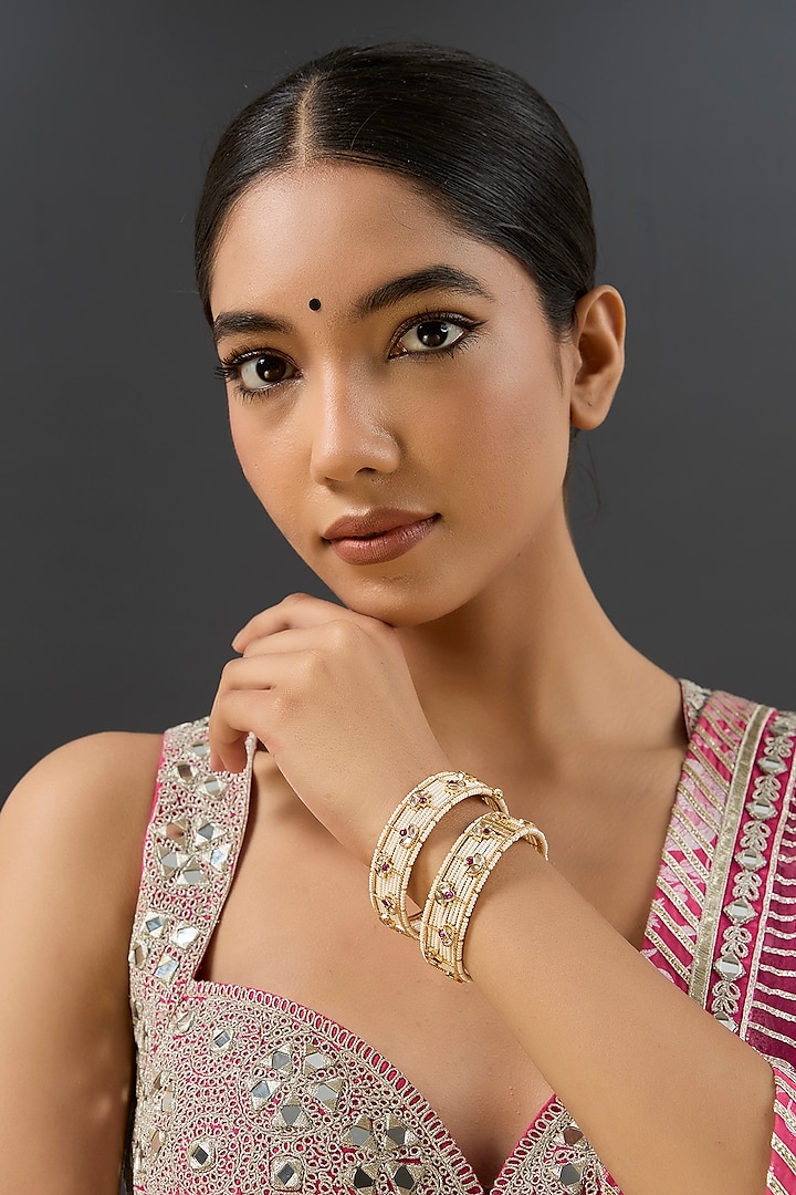 Gold Finish Kundan Polki & Red Stone Bangles (Set Of 2) by Zevar by Geeta at Pernia's Pop Up Shop